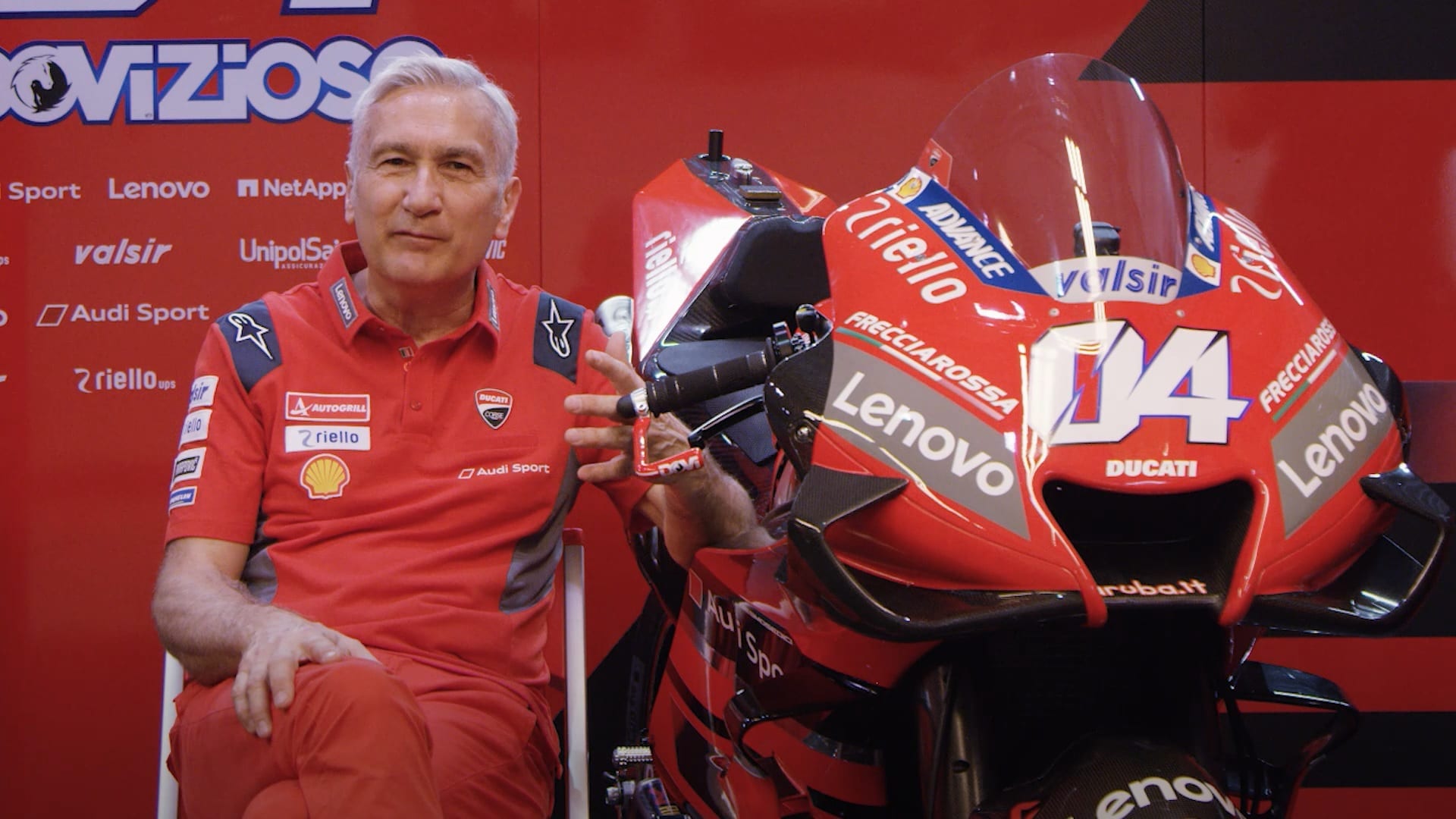 Ducati Team Manager Davide Tardozzi sitting beside a MotoGP bike