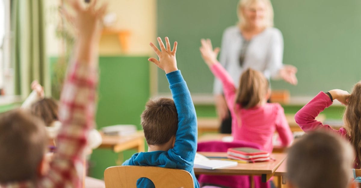 Students raising hands in a classroom